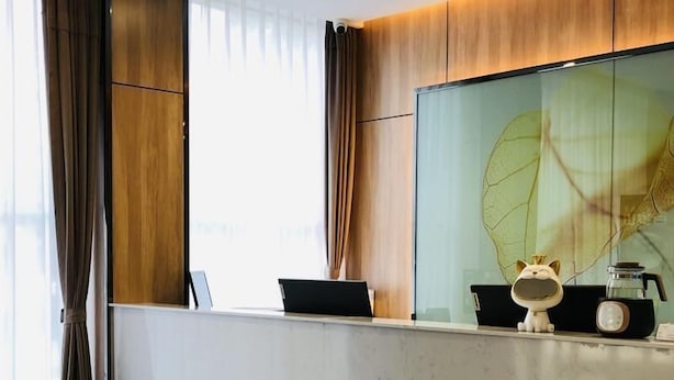 Un comptoir d’accueil moderne, équipé d’un ordinateur portable, d’un objet décoratif et d’une machine à café.