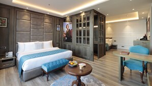 Una habitación de hotel moderna con una cama grande, una mesa de comedor y una zona de estar.