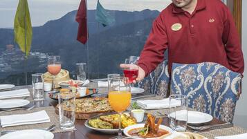 A dining table set with various dishes, glasses, and a person in a chef's uniform.