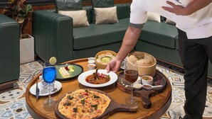 Un comedor con techo de madera, ventanas amplias y un sofá verde.