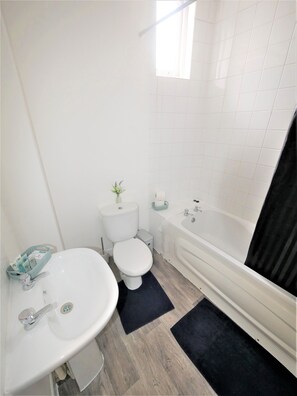 Bathtub, hair dryer, towels, shampoo