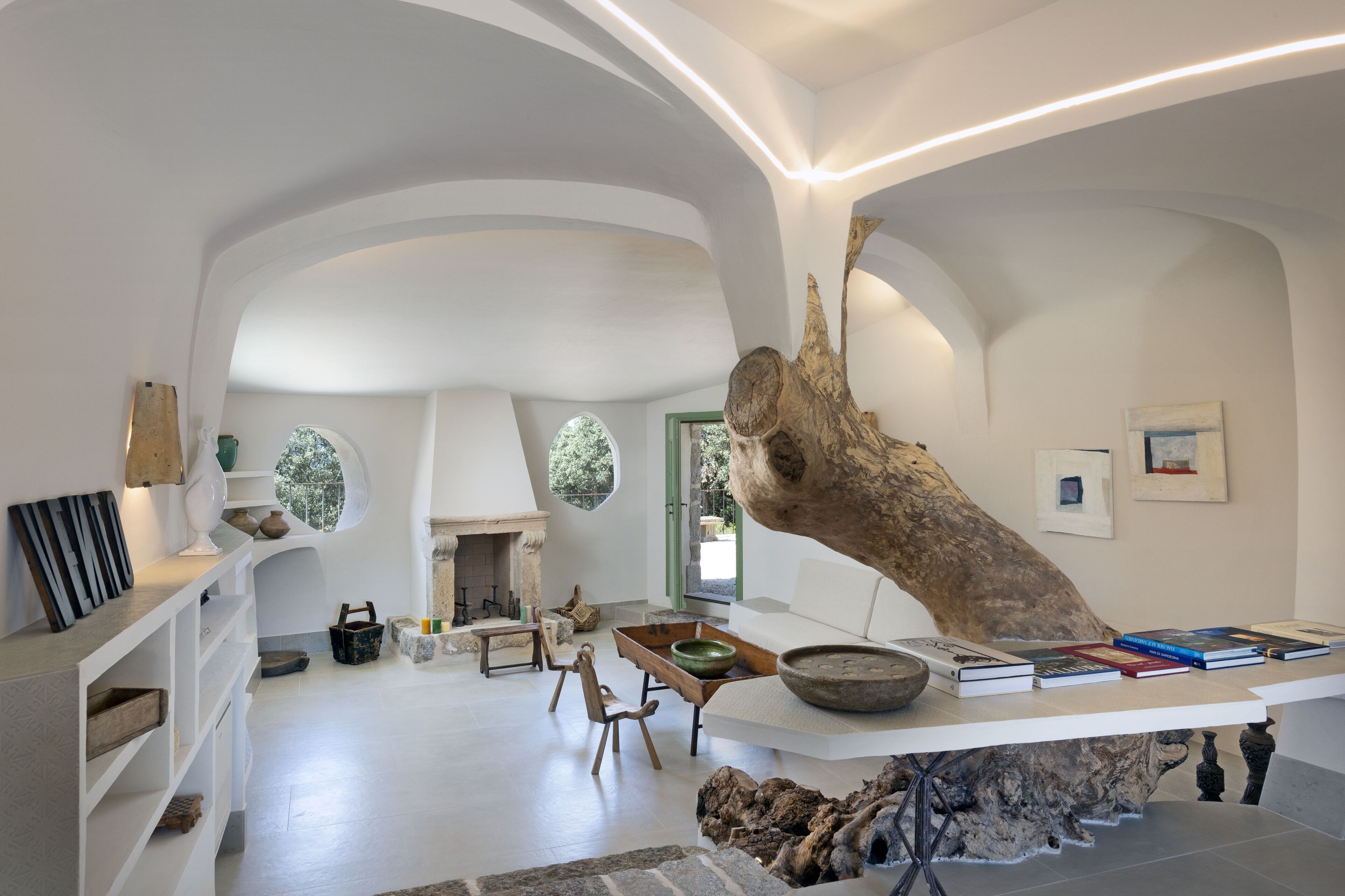 A spacious interior with a high ceiling, a fireplace, and a large wooden sculpture.