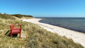 A beach with a red bench and grassy dunes. - Nice home in Aakirkeby with WiFi (Aakirkeby)