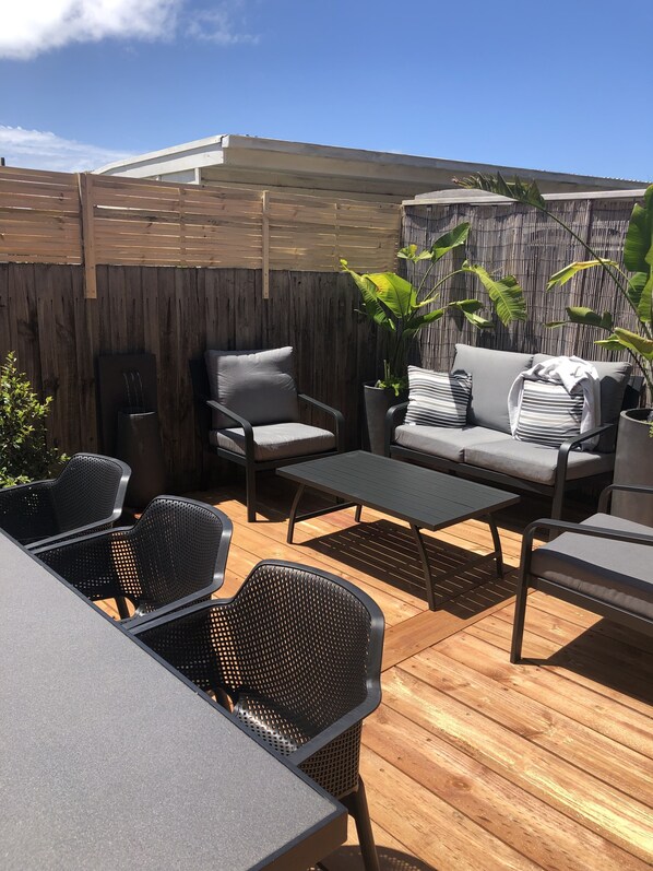 Relax on the patio with a sofa, armchairs, and a small table.