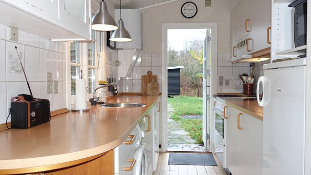 A modern kitchen with a wooden countertop, stainless steel sink, and pendant lights. - Stunning home in Aakirkeby with WiFi (Aakirkeby)