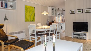 A modern living room with a dining area, a kitchen, and a TV. - Stunning home in Aakirkeby with WiFi (Aakirkeby)