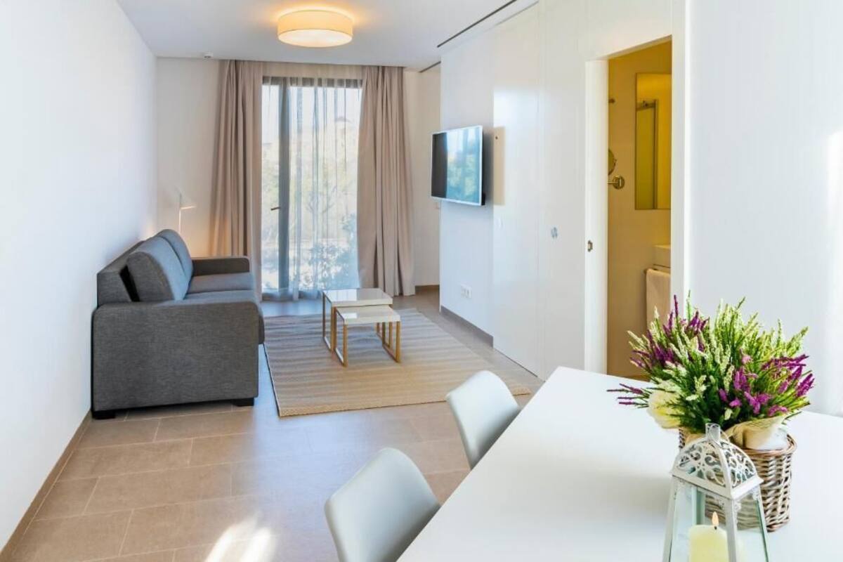 Een moderne woonkamer met een bank, een eettafel en een televisie.