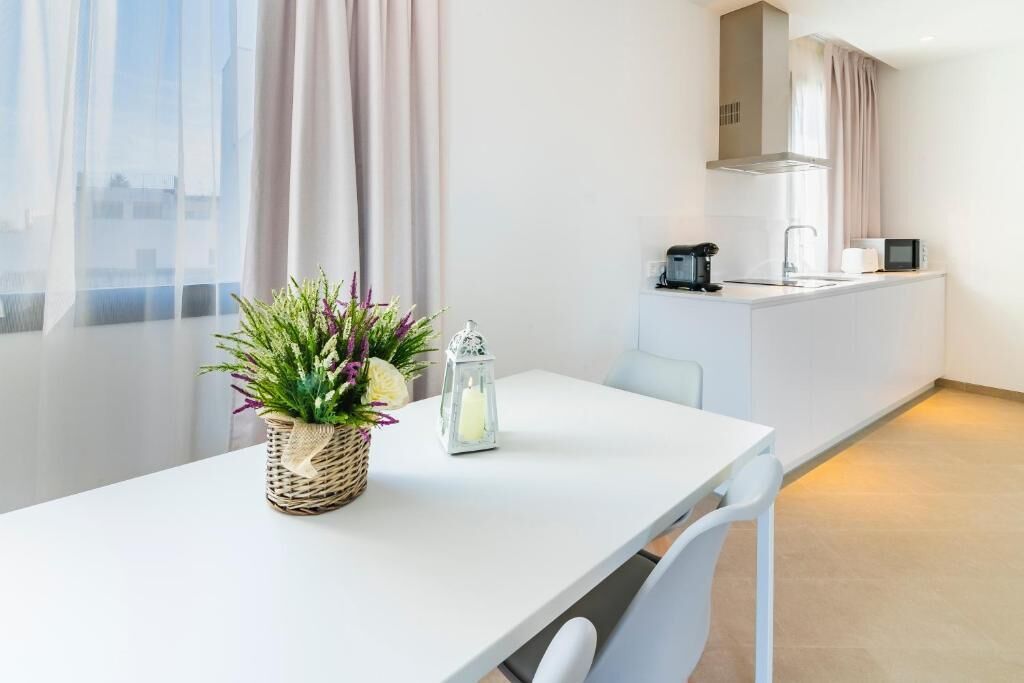 A modern kitchen with a white countertop, a coffee machine, and a microwave.