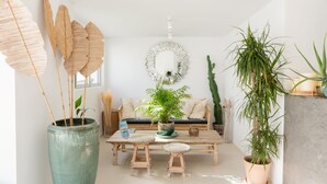 A modern living room with a large green vase, a round mirror, and various plants. - The Olive Boutique Suites and Spa (Santa Eulalia del Rio)