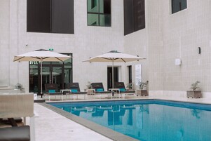 Una piscina al aire libre, sombrillas