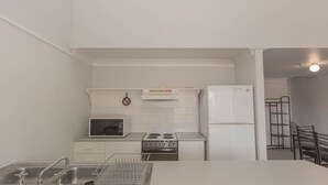 Une cuisine de taille réduite équipée d’un four à micro-ondes, d’une cuisinière et d’un réfrigérateur.
