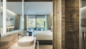 A modern bathroom with a large mirror, a bathtub, a shower, and a view of the outdoors.
