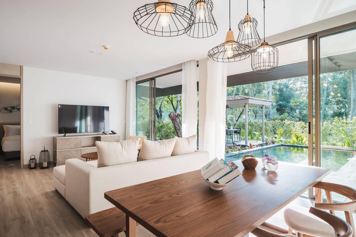 Una sala de estar moderna con una mesa de comedor de madera, un sofá y un televisor.
