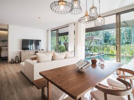 Una sala de estar moderna con una mesa de comedor de madera, un sofá y un televisor.