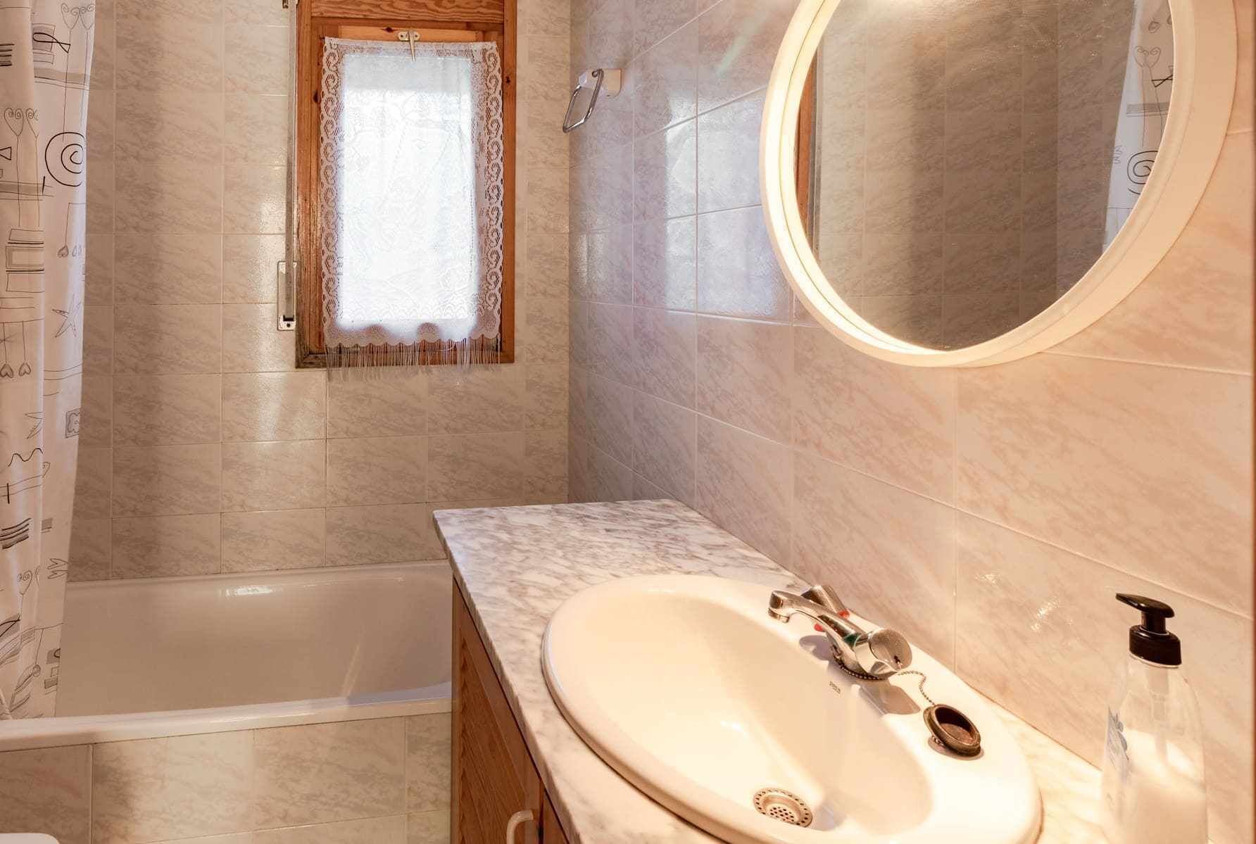 Une salle de bain avec une baignoire, un lavabo avec un miroir et un rideau de douche orné de motifs de notes de musique.