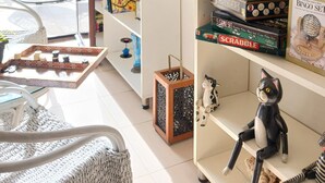Une pièce avec une bibliothèque, un fauteuil suspendu et un jeu de Scrabble.