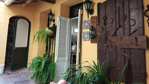 A traditional entrance with a wooden door, a green gate, and a tiled floor. - Casa Rogelio Inchauspi Bastida TRINIDAD (Trinidad)