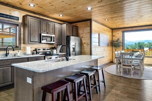Enjoy meals in the spacious kitchen with a large island, stainless steel appliances, and granite countertops.