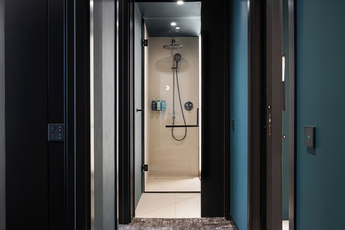 A modern bathroom with a shower, a toilet, and a sink.