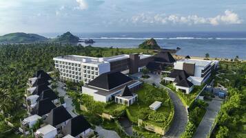 A resort with multiple buildings, a central courtyard, and a view of the ocean.