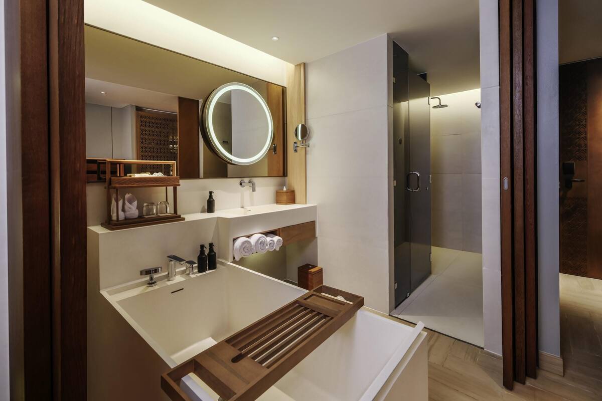 Une salle de bain moderne avec un grand miroir, un lavabo intégré et une douche à l’italienne.