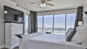 Ein Schlafzimmer mit einem großen Bett, einem Fernseher und Meerblick.