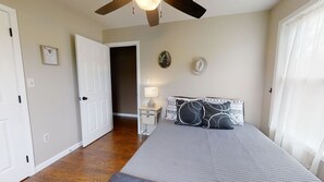 A bedroom with a bed, a nightstand, a ceiling fan, and a door to another room. - Wearadise Mountain Views Home features Hot Tub and Fire Pit by RedAwning (Sevierville)