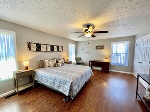 A bedroom with a bed, a desk, a chair, a ceiling fan, and a wardrobe. - Wearadise Mountain Views Home features Hot Tub and Fire Pit by RedAwning (Sevierville)