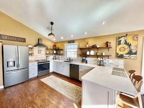 A modern kitchen with a central island, stainless steel appliances, and a farmhouse-style decor.