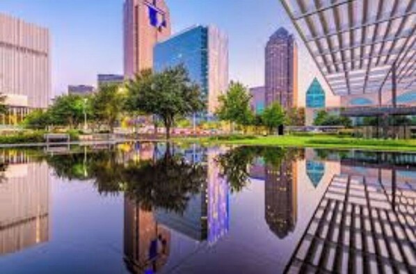A modern cityscape with high-rise buildings and a reflective water body.