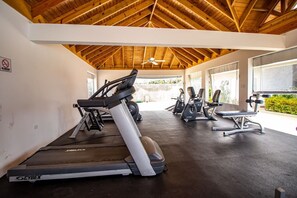 A gym with treadmills, elliptical machines, and a bench press. - Paradise Villa|Gated|Pool|Richmond (Ocho Rios)