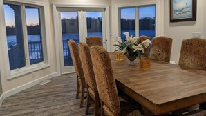 Un comedor con una mesa de madera, sillas estampadas y un jarrón de flores.