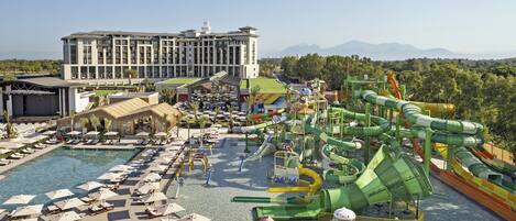 A resort with a large pool, water park, and a building with multiple floors.