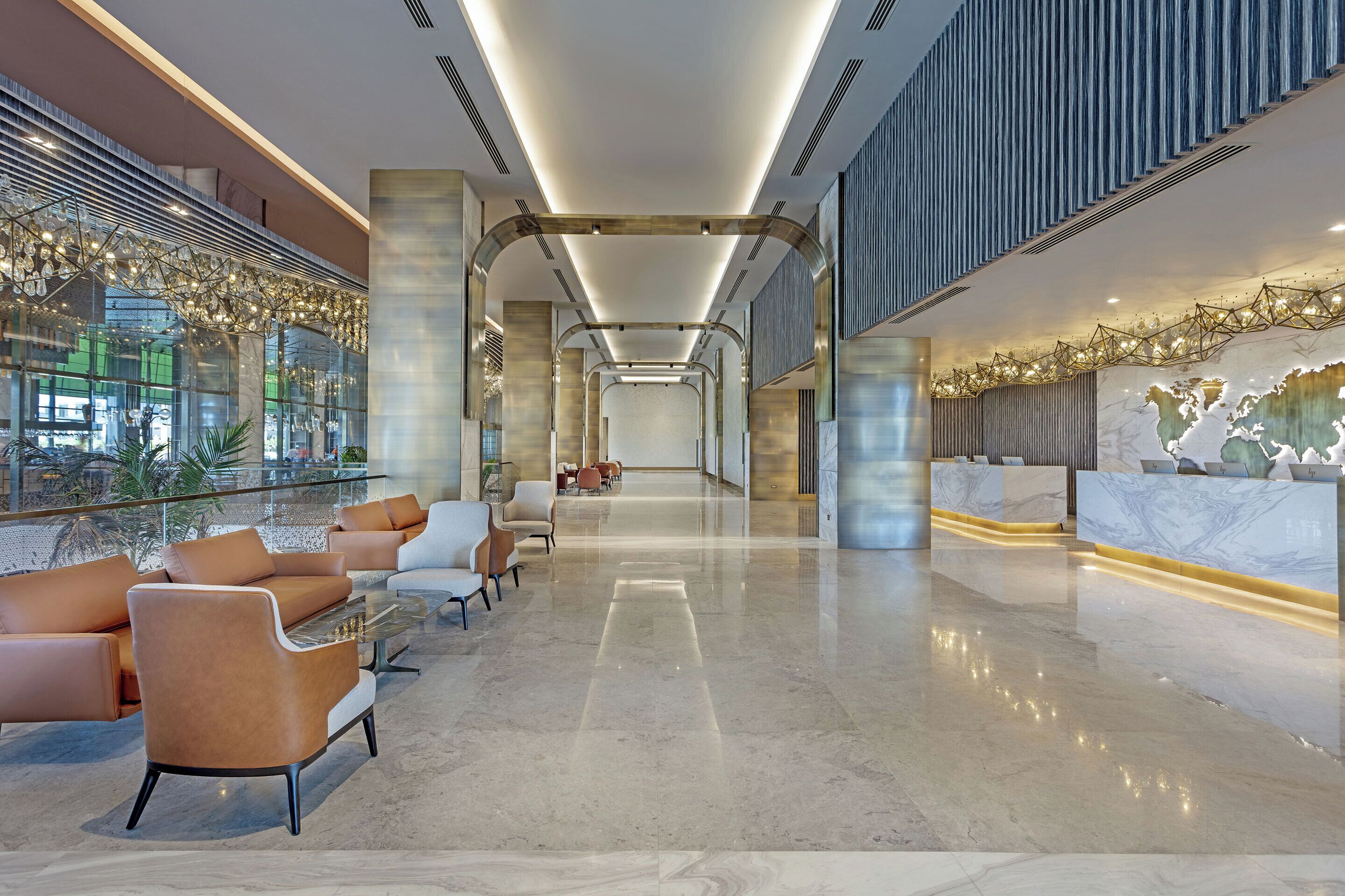 A modern lobby with a glass wall, seating area, reception desk, and a marble floor.