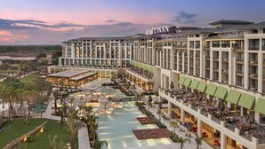 A hotel with multiple floors, a rooftop pool, and outdoor seating areas. - Cullinan Belek - All inclusive (Serik)