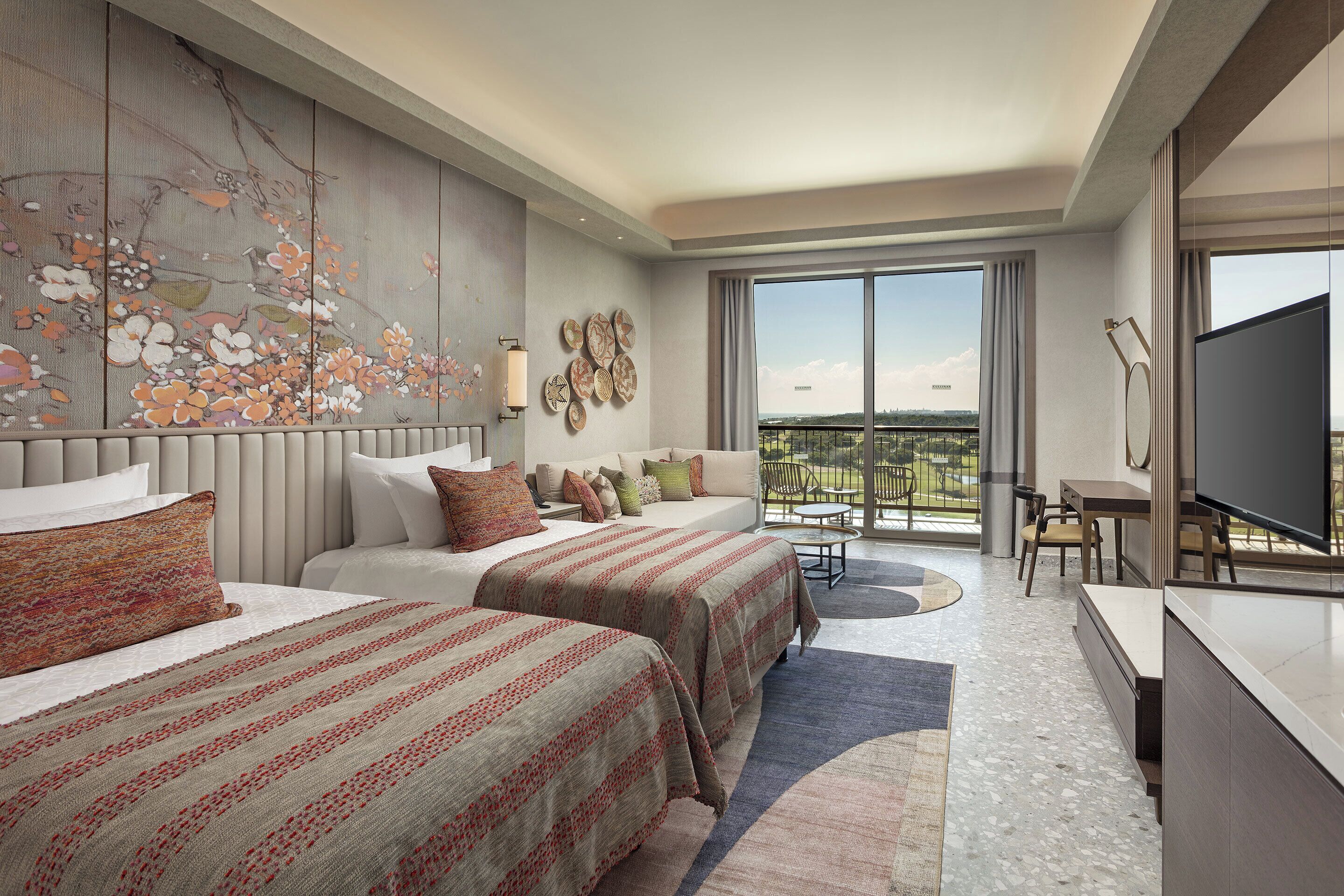 Une chambre d’hôtel avec deux lits, une grande fenêtre, un balcon et un téléviseur à écran plat.