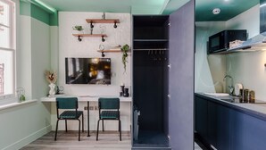 Una cocina moderna con comedor, televisor montado en la pared y microondas en la encimera.