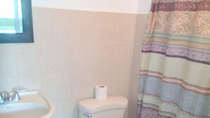 Ein Badezimmer mit Waschbecken, Toilette und einer duschkabine mit Muster.