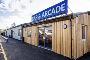 A building with a sign reading "BAR & ARCADE" and a wooden facade. - Fluffy Caravan Sleeps 4, Pet-friendly (Sheerness)