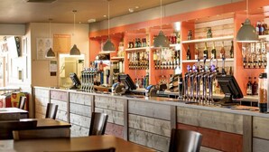 A bar area with multiple taps, shelves of bottles, and wooden paneling. - Fluffy Caravan Sleeps 4, Pet-friendly (Sheerness)