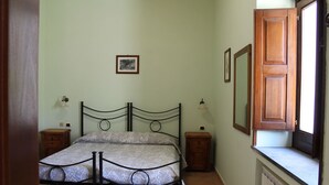 A bedroom with a bed, bedside tables, a mirror, and a window. - Amalfi double room (Gragnano)