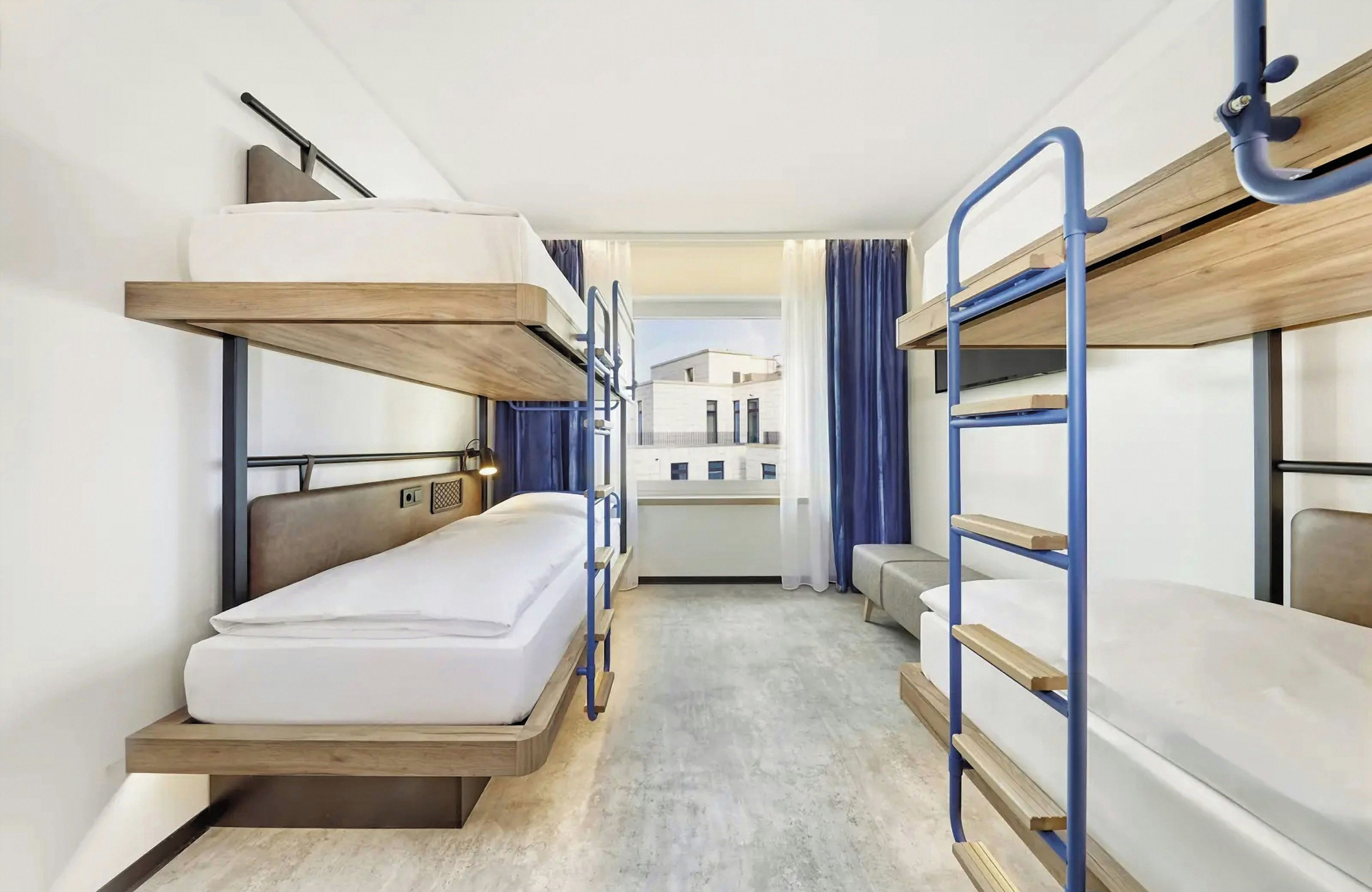 Habitación con literas y vista a un edificio.
