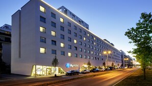 A modern hotel with a flat facade, multiple windows, and a visible entrance with cars parked outside. - H2 Hotel Düsseldorf City (Düsseldorf)