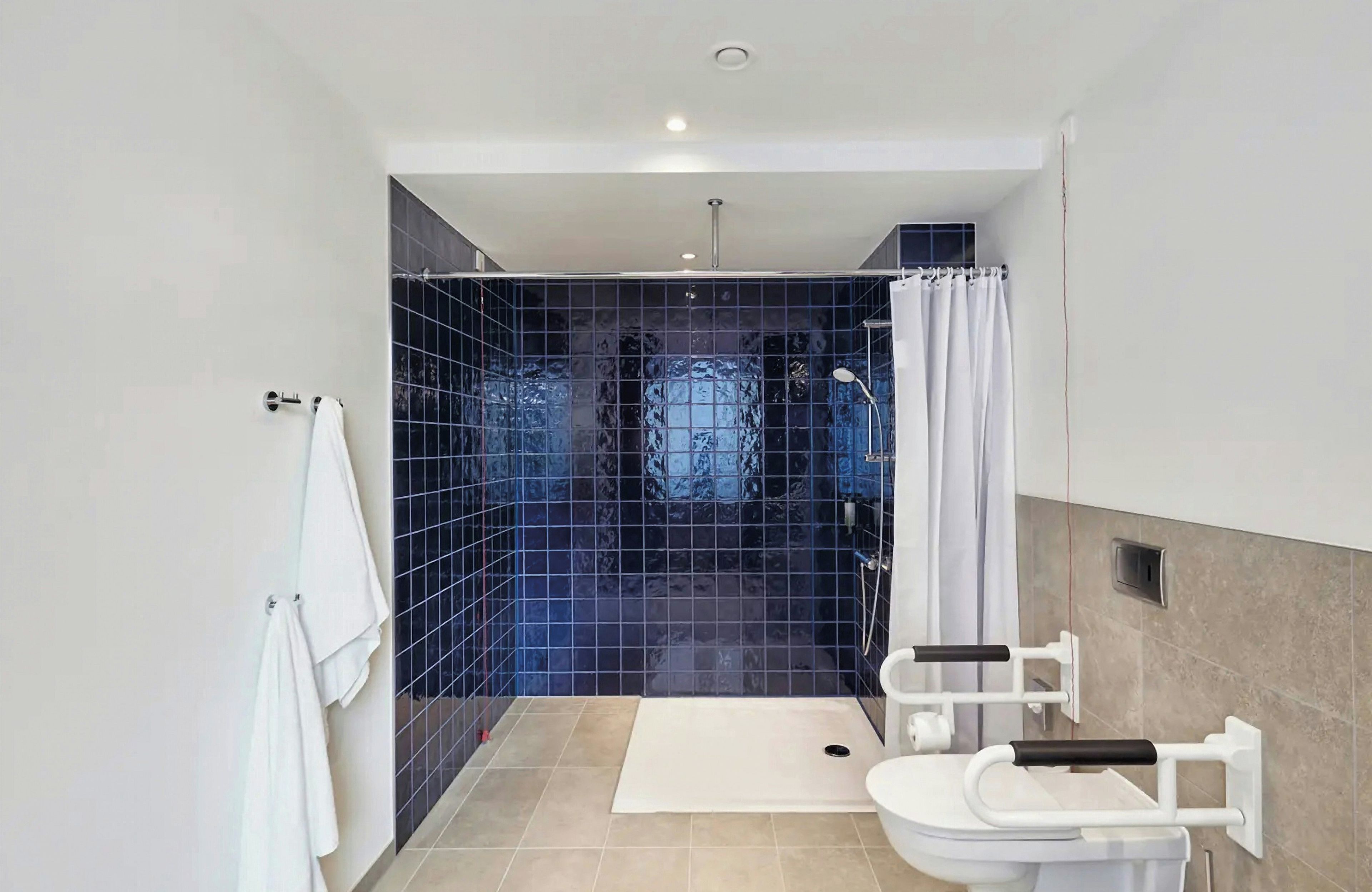 Un baño moderno con ducha, inodoro y toallero.