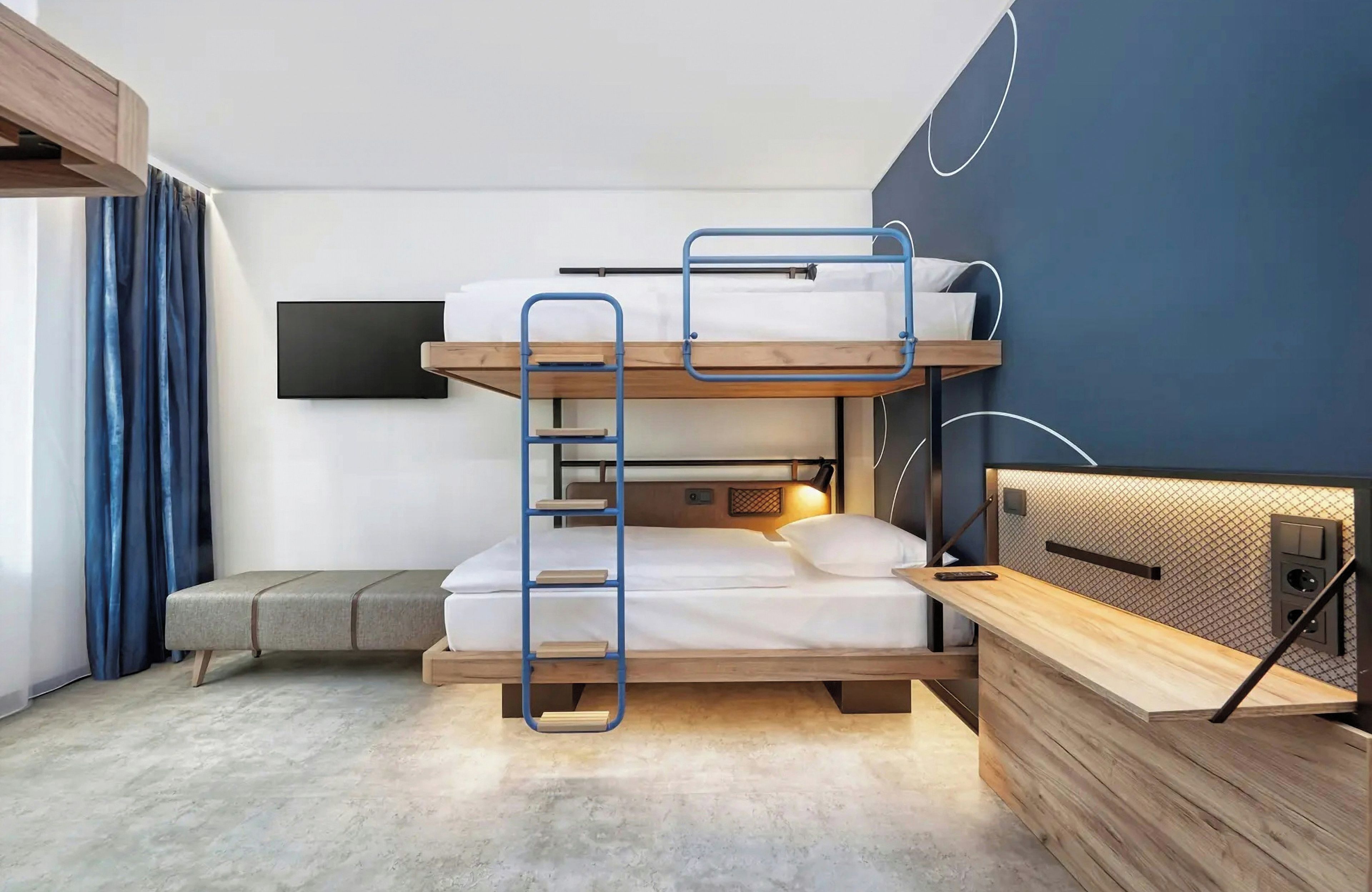 A bunk bed with a ladder, a desk, and a wall-mounted TV in a modern room.