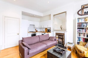 Un salon moderne comprenant un canapé, une table basse, une cheminée et une bibliothèque.