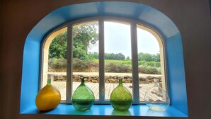 A window with four glass vases on a blue ledge. - In the heart of Vineyards (LA REOLE)