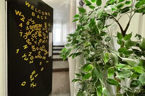 Welcome to a modern space with a casual, welcoming atmosphere, featuring a potted plant and a staircase leading to additional levels.