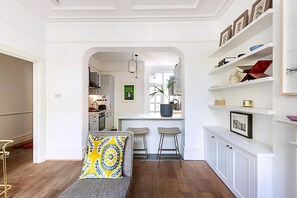 A modern interior with a sofa, a kitchen, and a bar area. - Stunning Maida Vale Apartment (London)