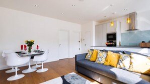 Ein modernes Wohnzimmer mit einer Couch, einem Esstisch und Stühlen.